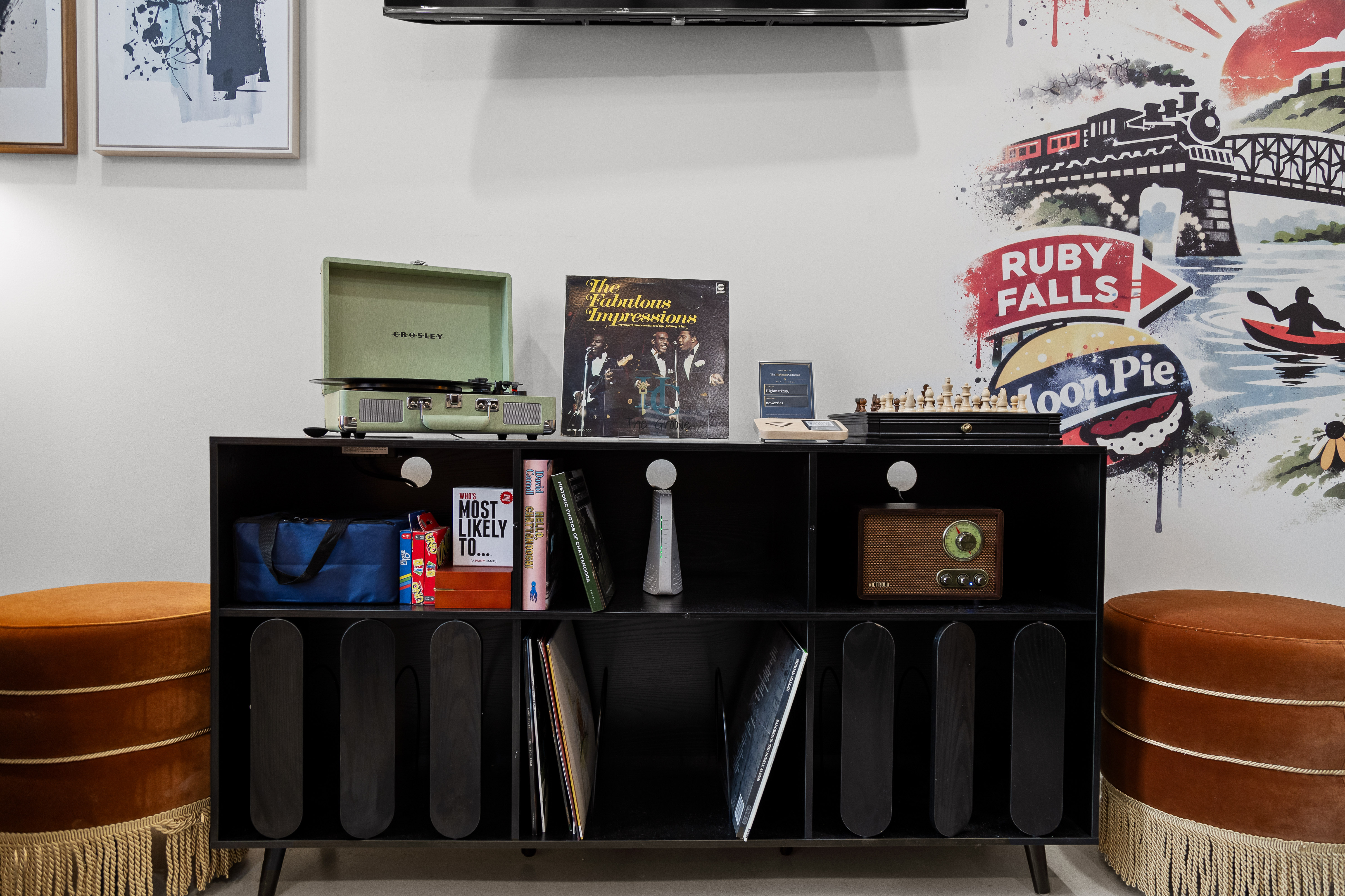 Retro record player nook with local art, vinyls, and cozy velvet seating