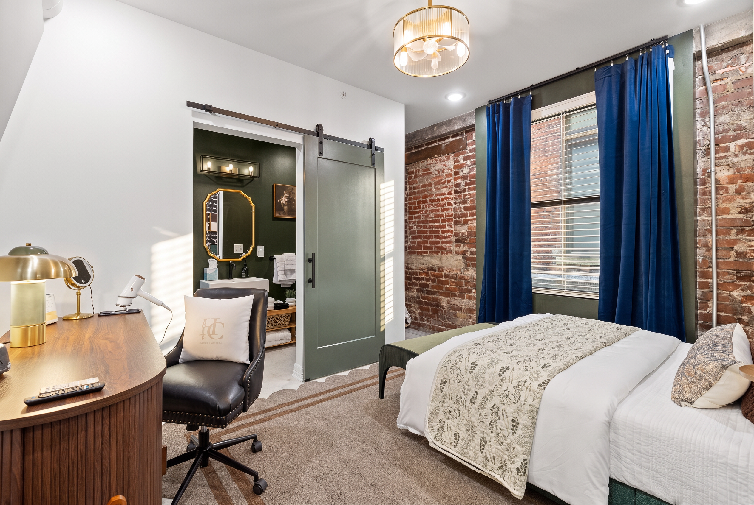 Cozy brick-accent bedroom with workspace and elegant en-suite bath