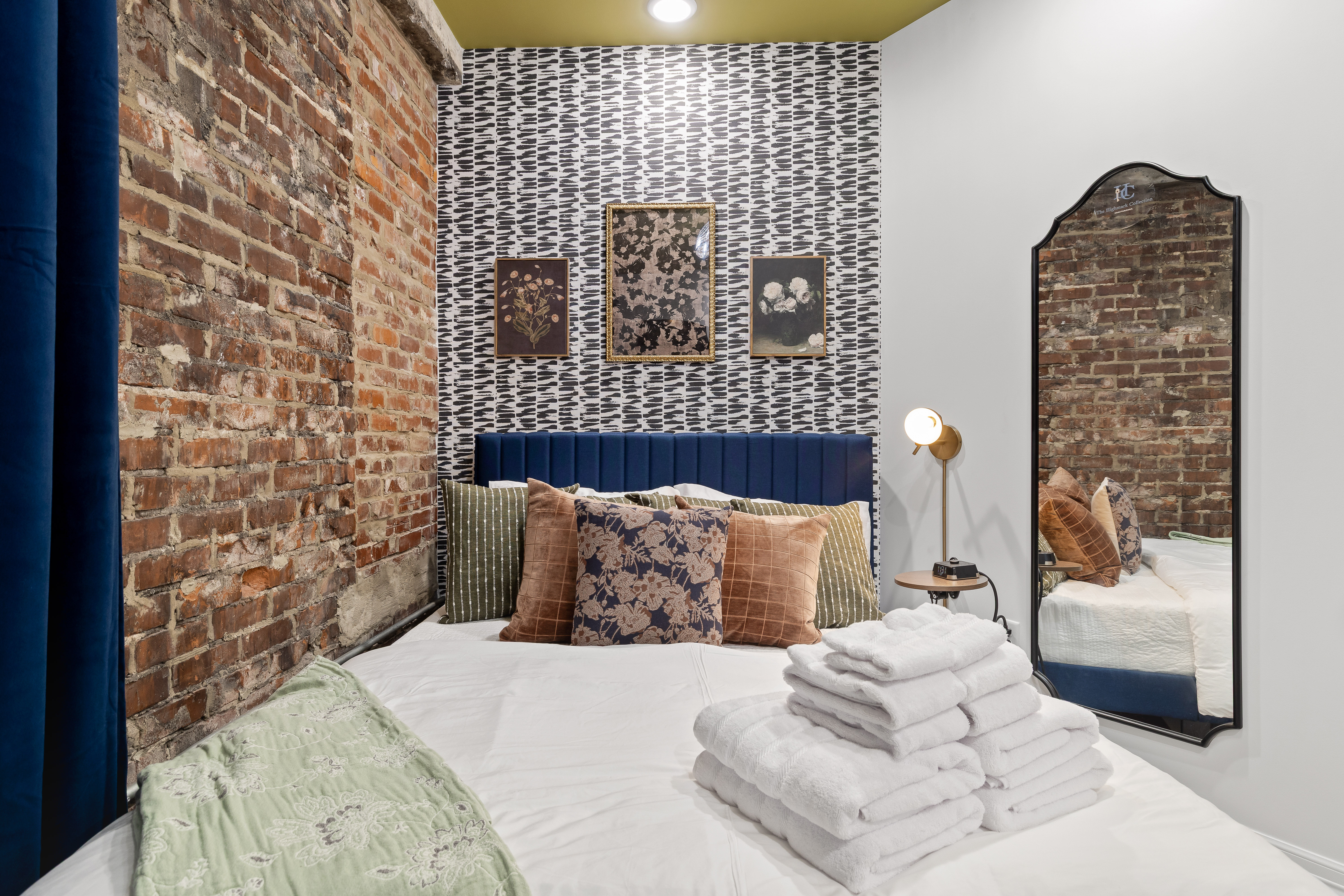 Chic brick-walled bedroom with plush linens and boutique-style design