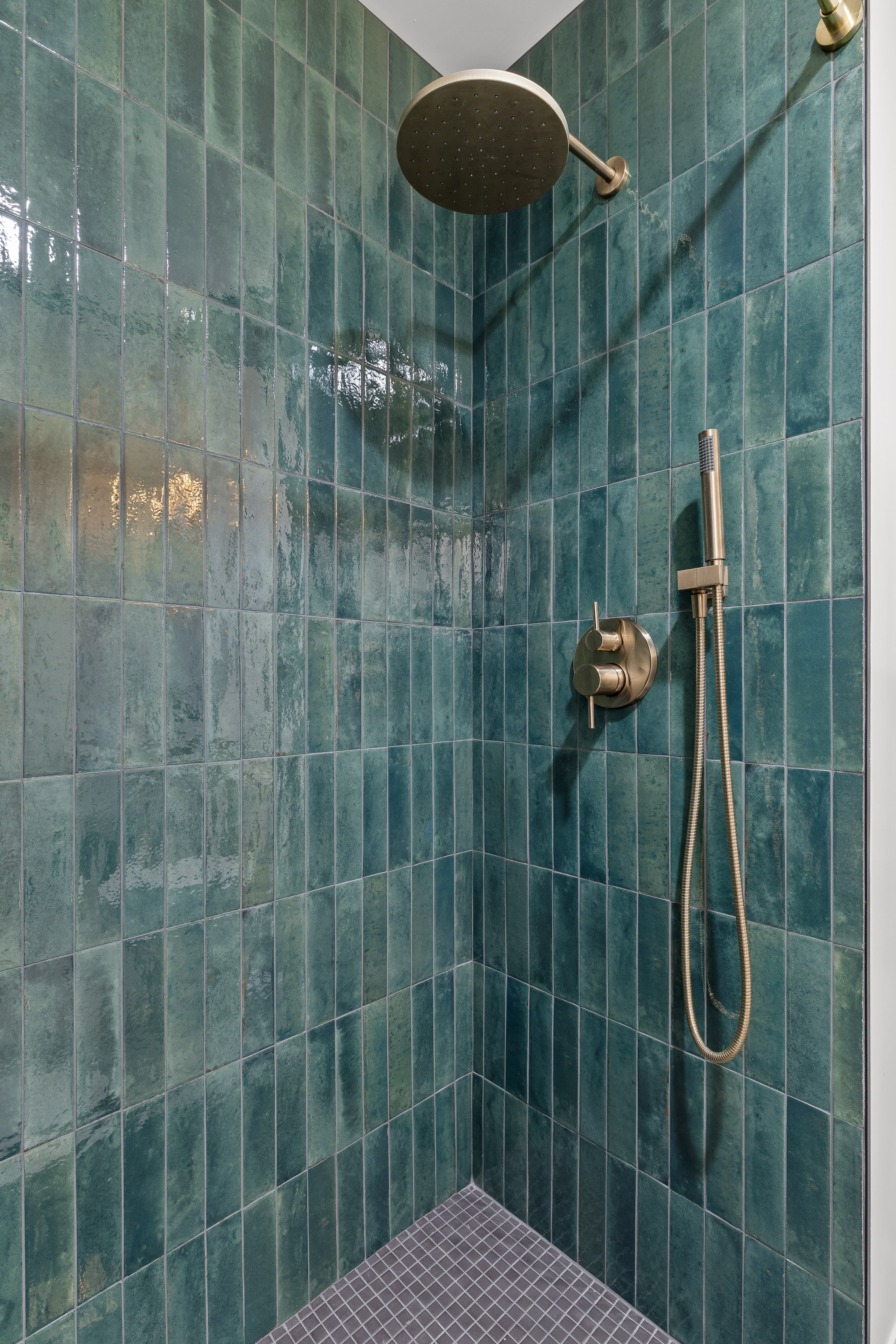 Spa-style walk-in shower with rainfall head and striking blue tile