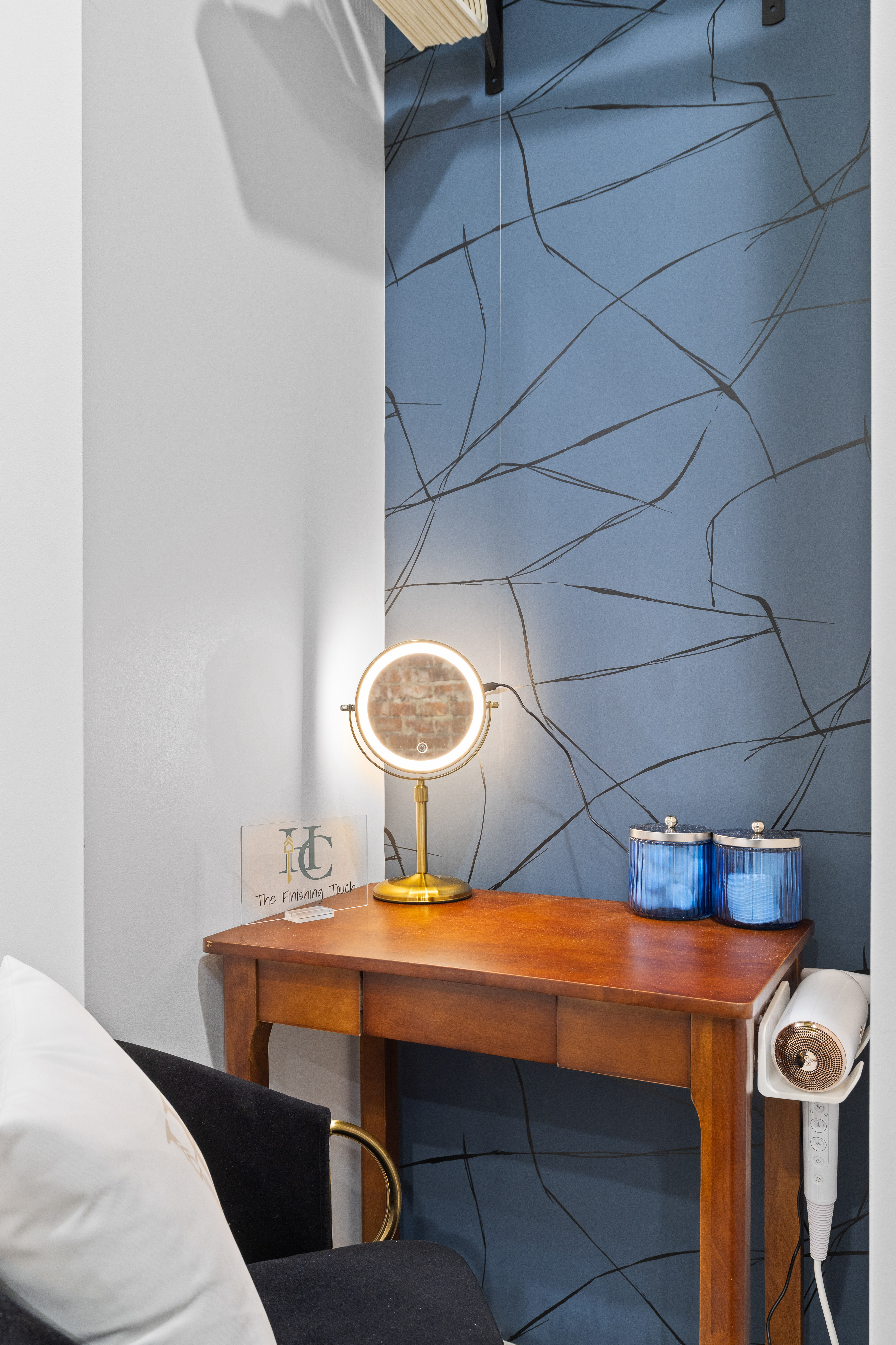 Chic vanity nook with lighted mirror and modern blue accent wall