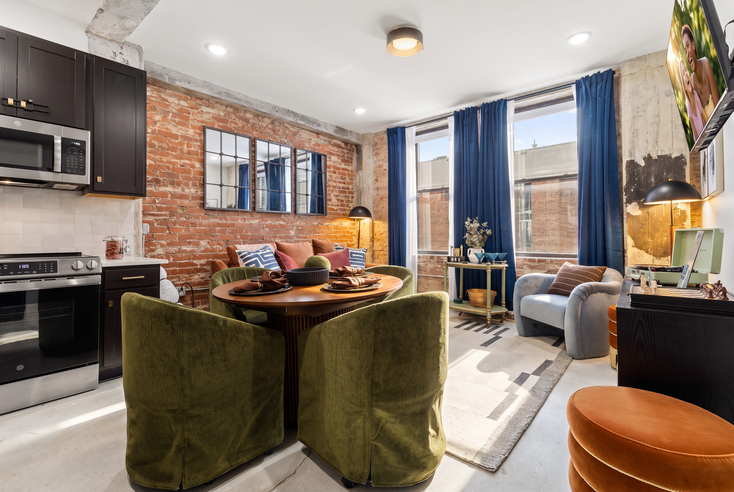 Stylish loft-style living with exposed brick, velvet seating, and bright windows