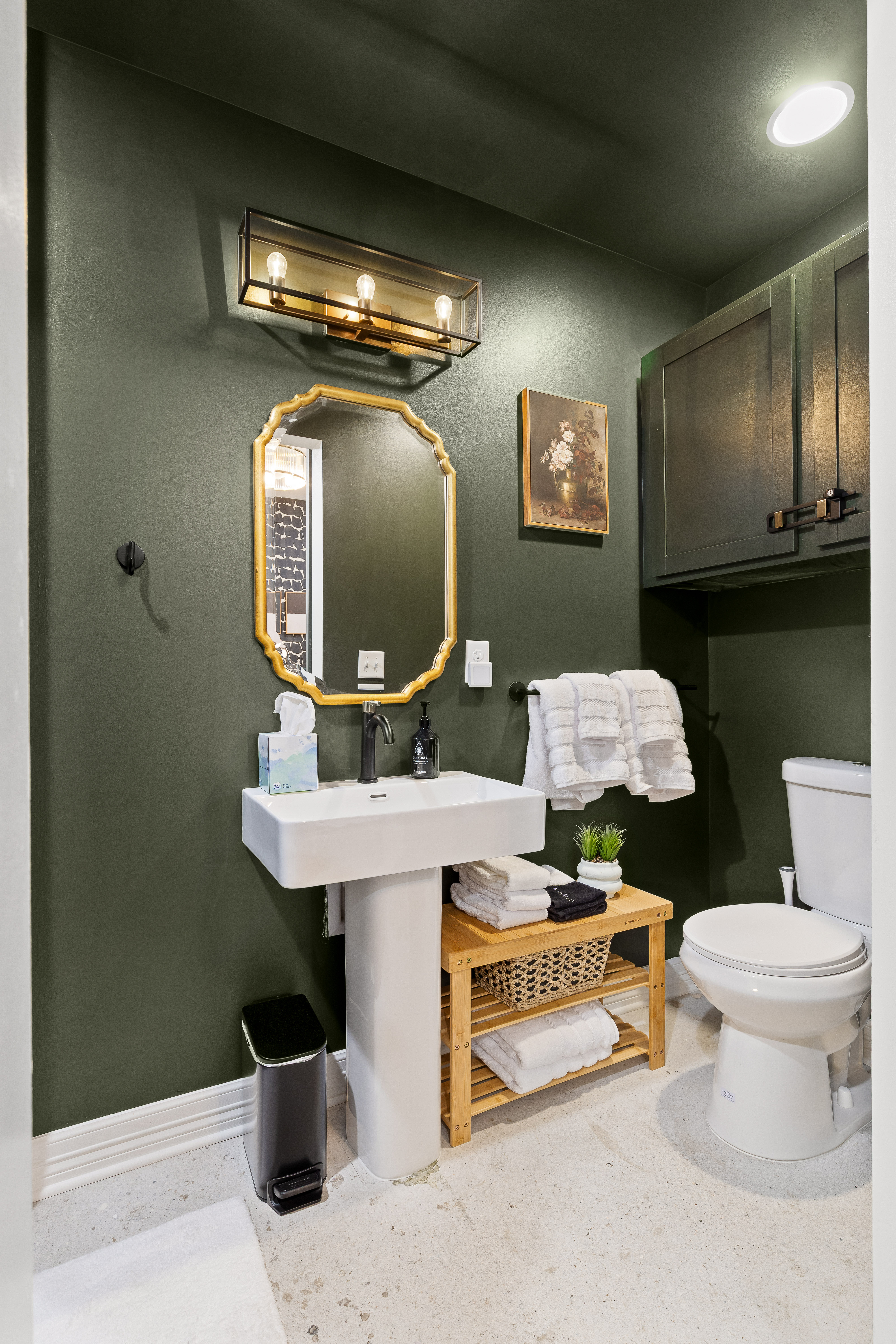 Moody modern half bath with luxe touches and thoughtful guest amenities