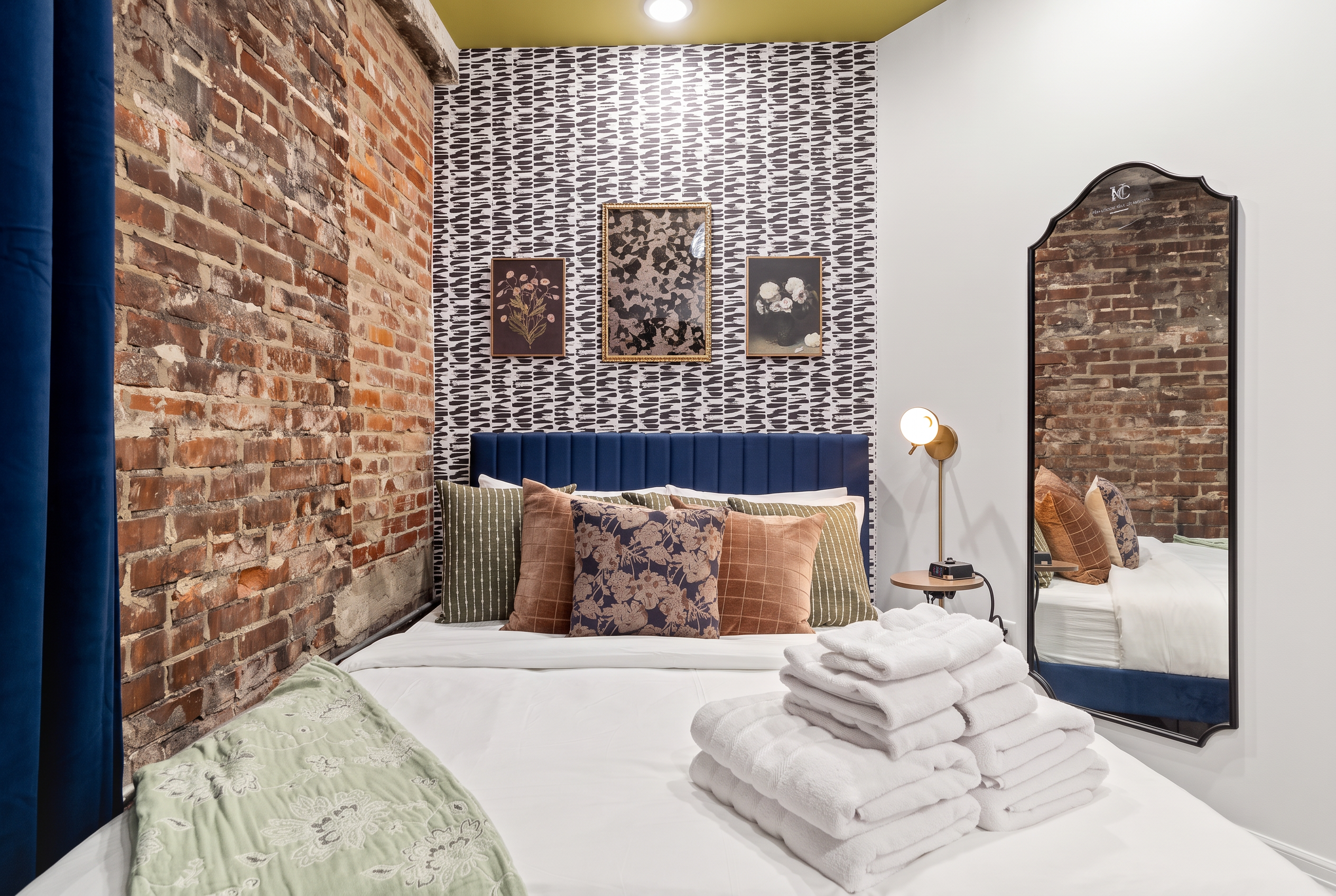 Chic brick-walled bedroom with boutique style and cozy designer touches