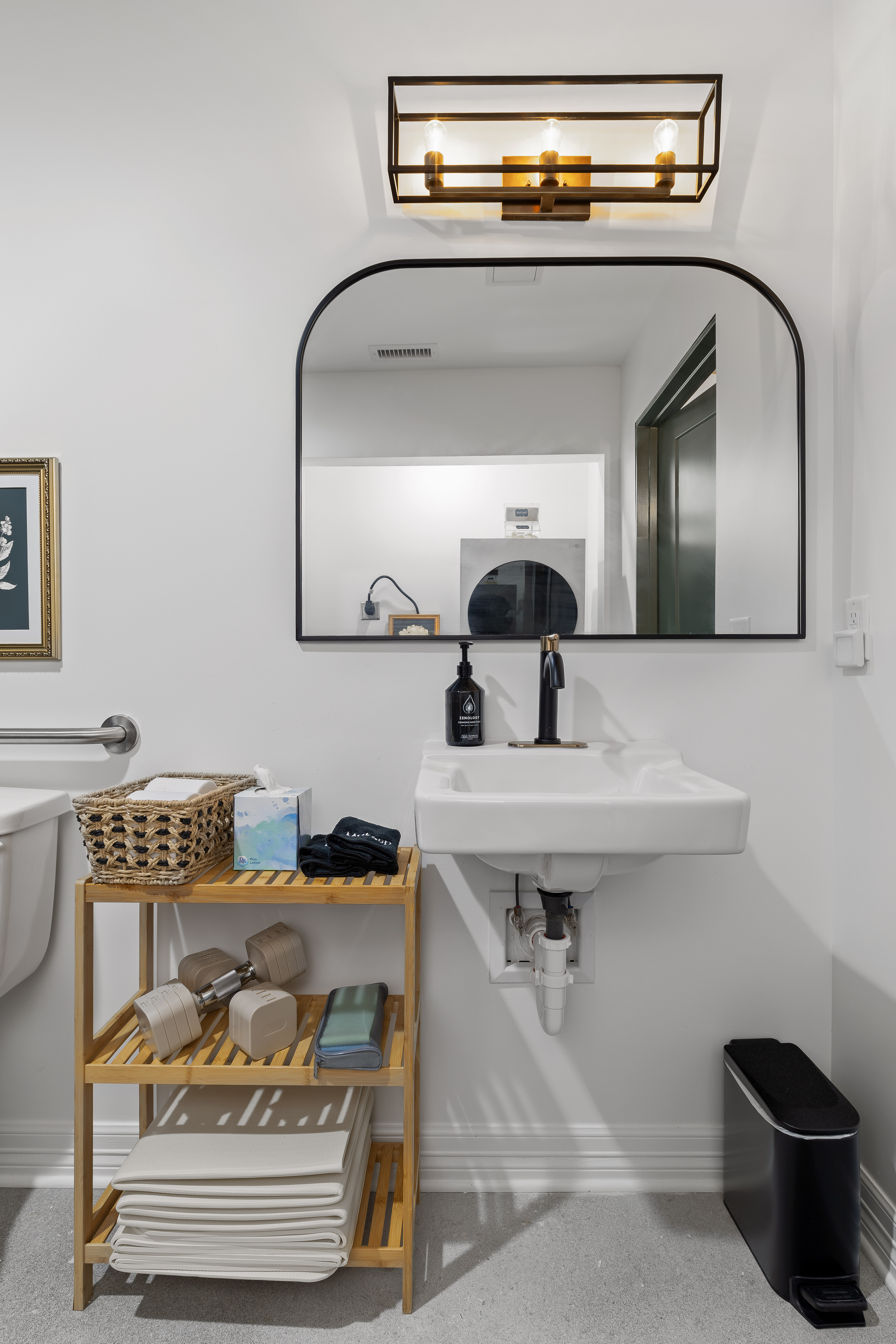 Bright modern bathroom with arched mirror and stylish open shelving
