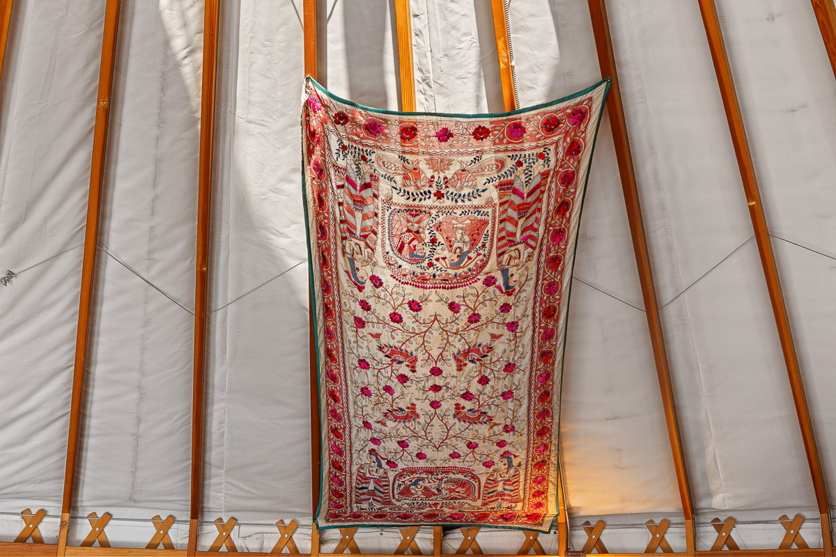 Handcrafted tapestry and warm wood beams add charm to this cozy yurt.