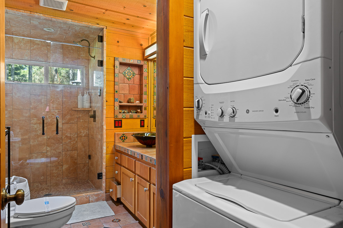 Rustic bath with walk-in shower + in-unit laundry, colorful tile charm
