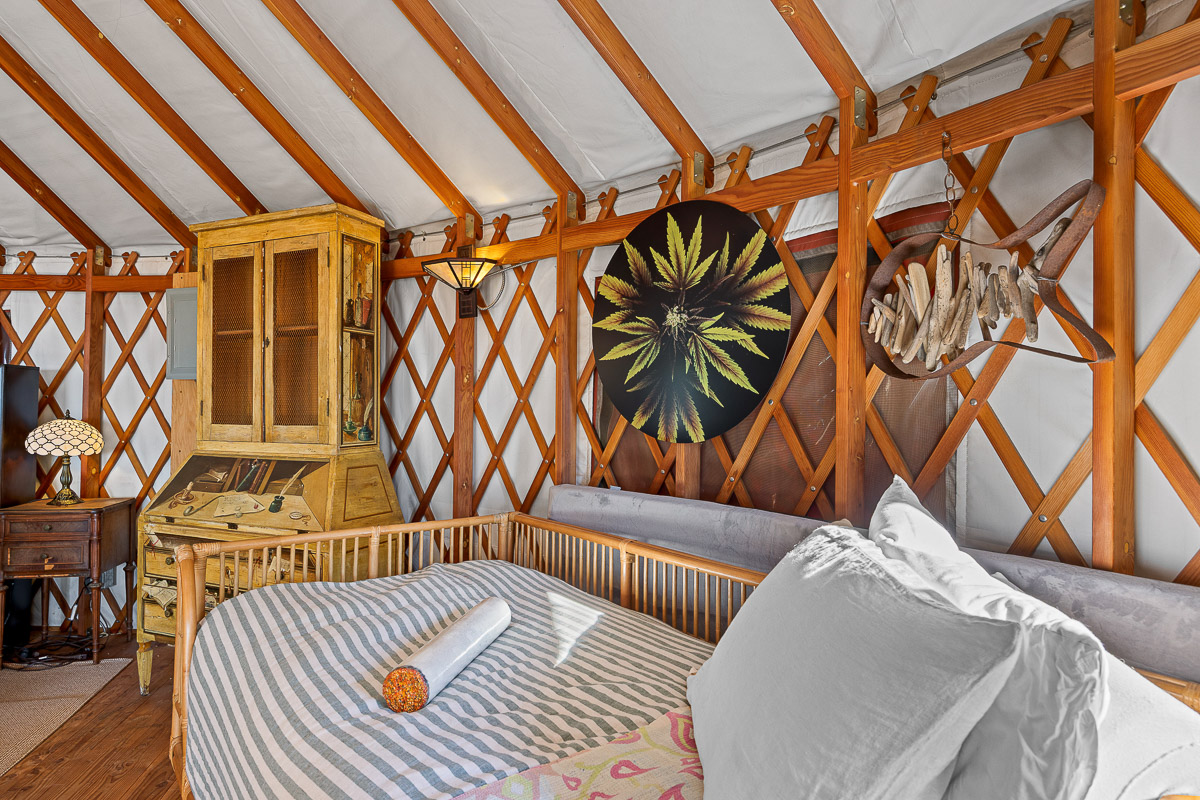 Cozy yurt bedroom with rustic desk, warm lighting, and boho charm