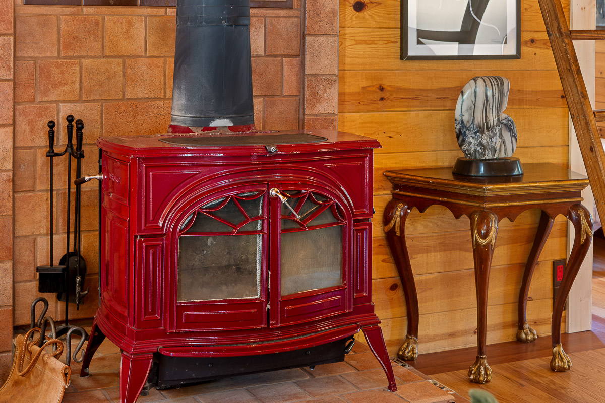 Charming red enamel wood stove in a warm, artful cabin corner