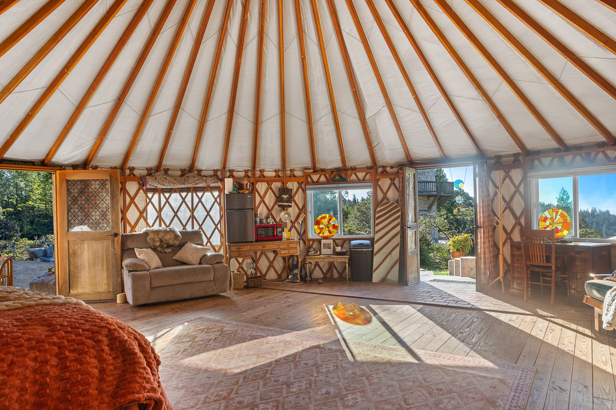 Sunlit yurt retreat with forest views, kitchenette, cozy lounge, and workspace