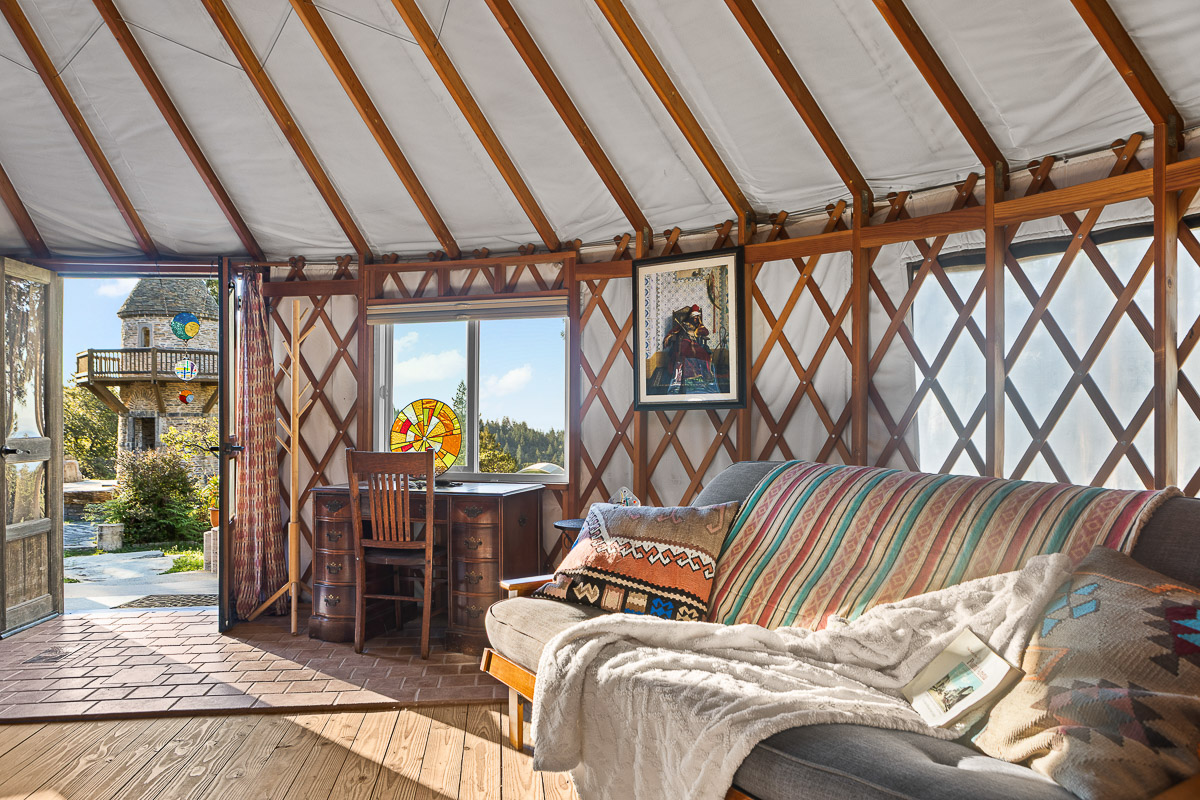 Sunny yurt with cozy lounge, stained glass, and hillside views