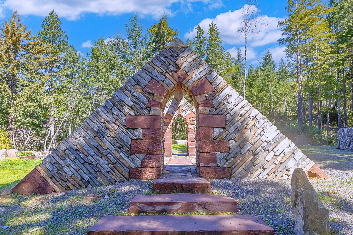 Striking stone pyramid arch in forest—perfect for photos & ceremonies.