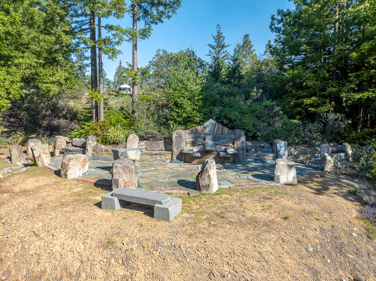 Secluded stone amphitheater for gatherings beneath tall pines