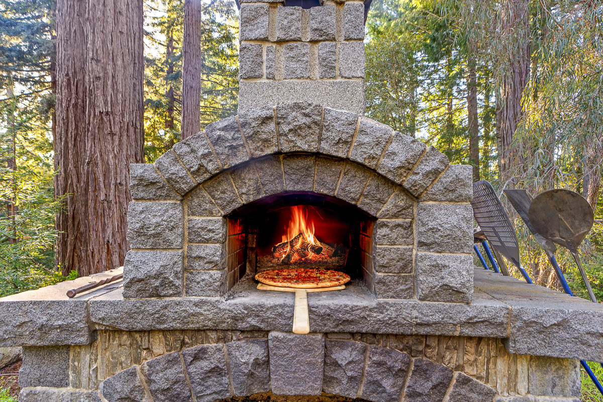 Forest-side wood‑fired pizza oven—craft pies under towering redwoods.