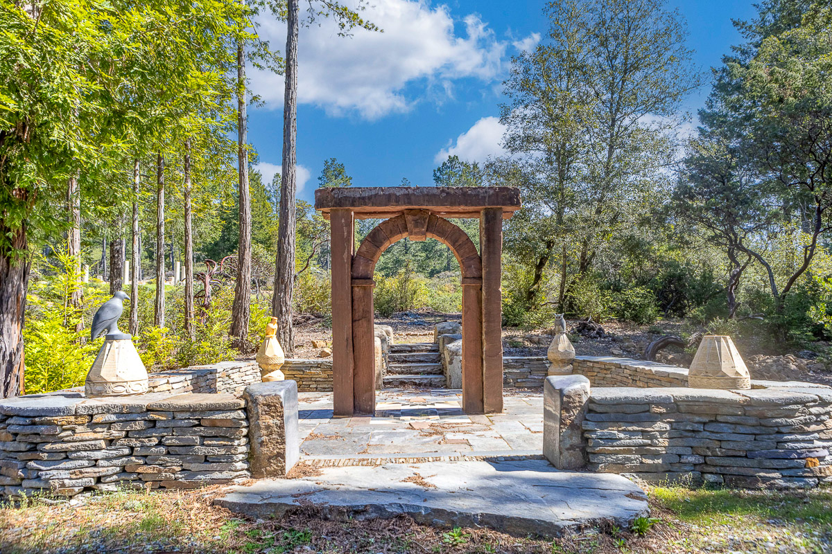 Tranquil forest garden with rustic stone arch and sculpted accents