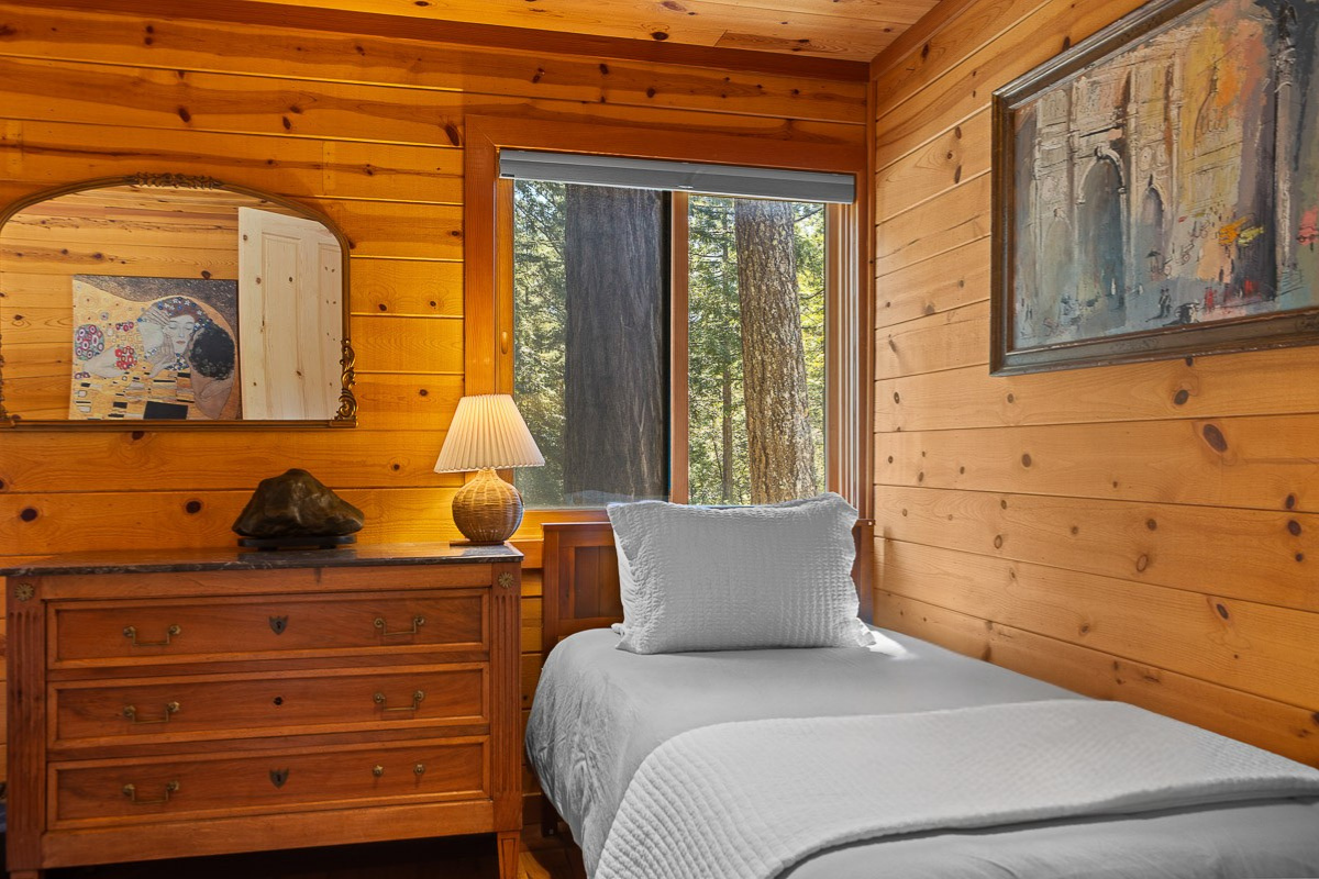 Cozy twin room with forest view, warm wood paneling, rustic charm