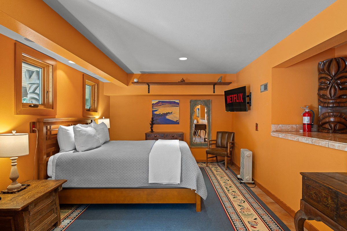 Warm, tiki-accented suite with king bed, seating nook & Netflix-ready TV