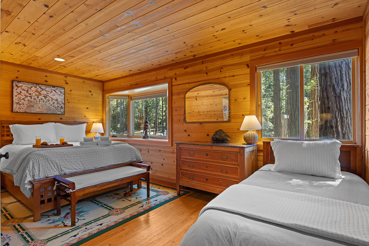 Cozy wood-paneled bedroom with forest views, king + twin beds