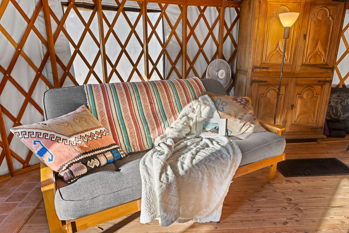 Cozy yurt lounge with boho sofa, soft throws, and warm wood charm