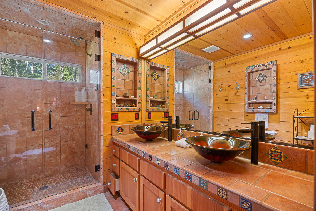 Rustic spa bath with dual vessel sinks and large glass walk-in shower