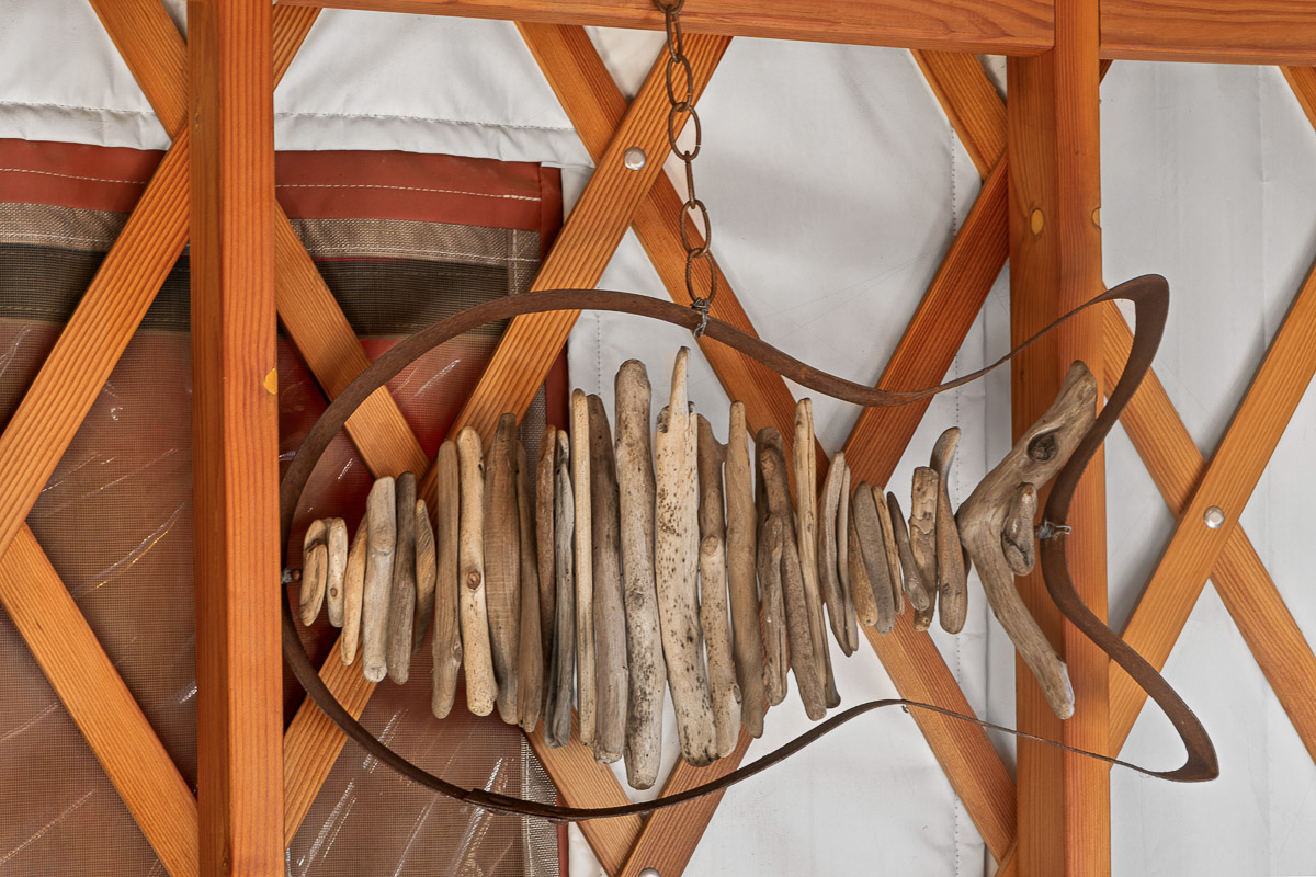 Handcrafted driftwood fish decor—rustic charm in cozy yurt.
