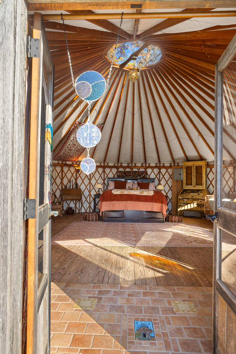 Sunny yurt retreat with skylight, cozy queen bed, and rustic charm.
