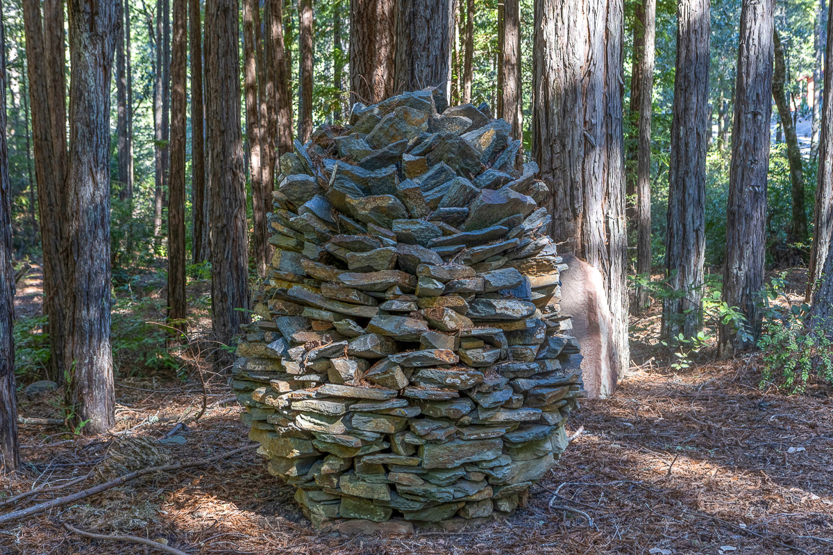 Woodland art: stacked-stone sculpture amid towering trees