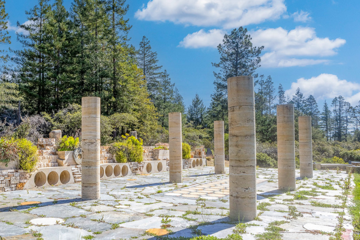 Sculptural stone terrace amid towering pines—perfect for gatherings