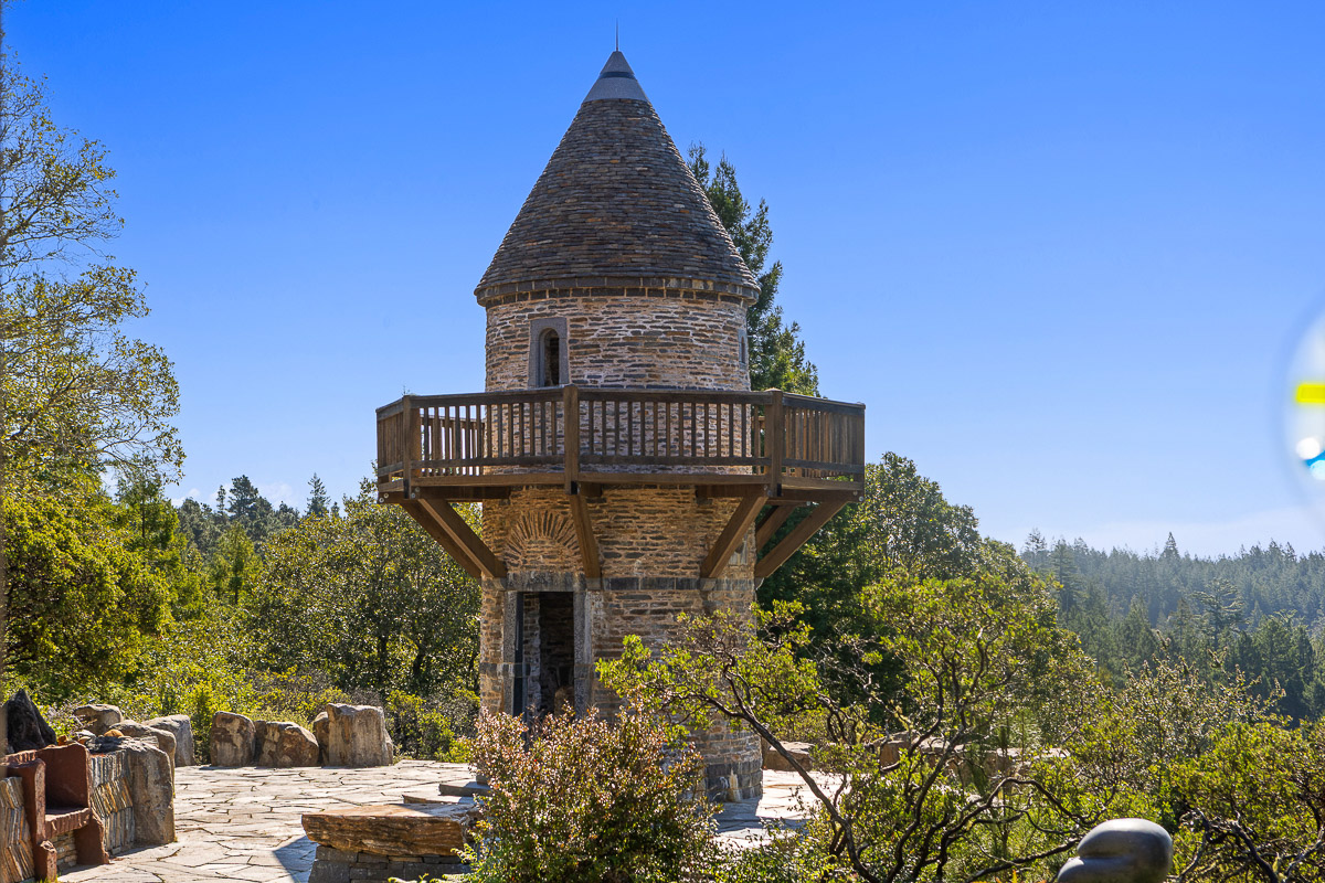 Storybook stone tower with wraparound deck and sweeping forest views