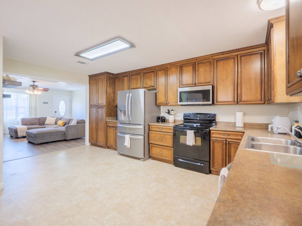 Open kitchen with stainless appliances looking into the living room