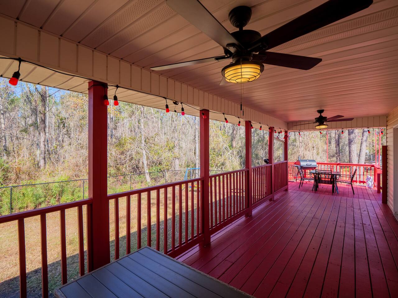 Covered deck with ceiling fans overlooking the wooded backyard