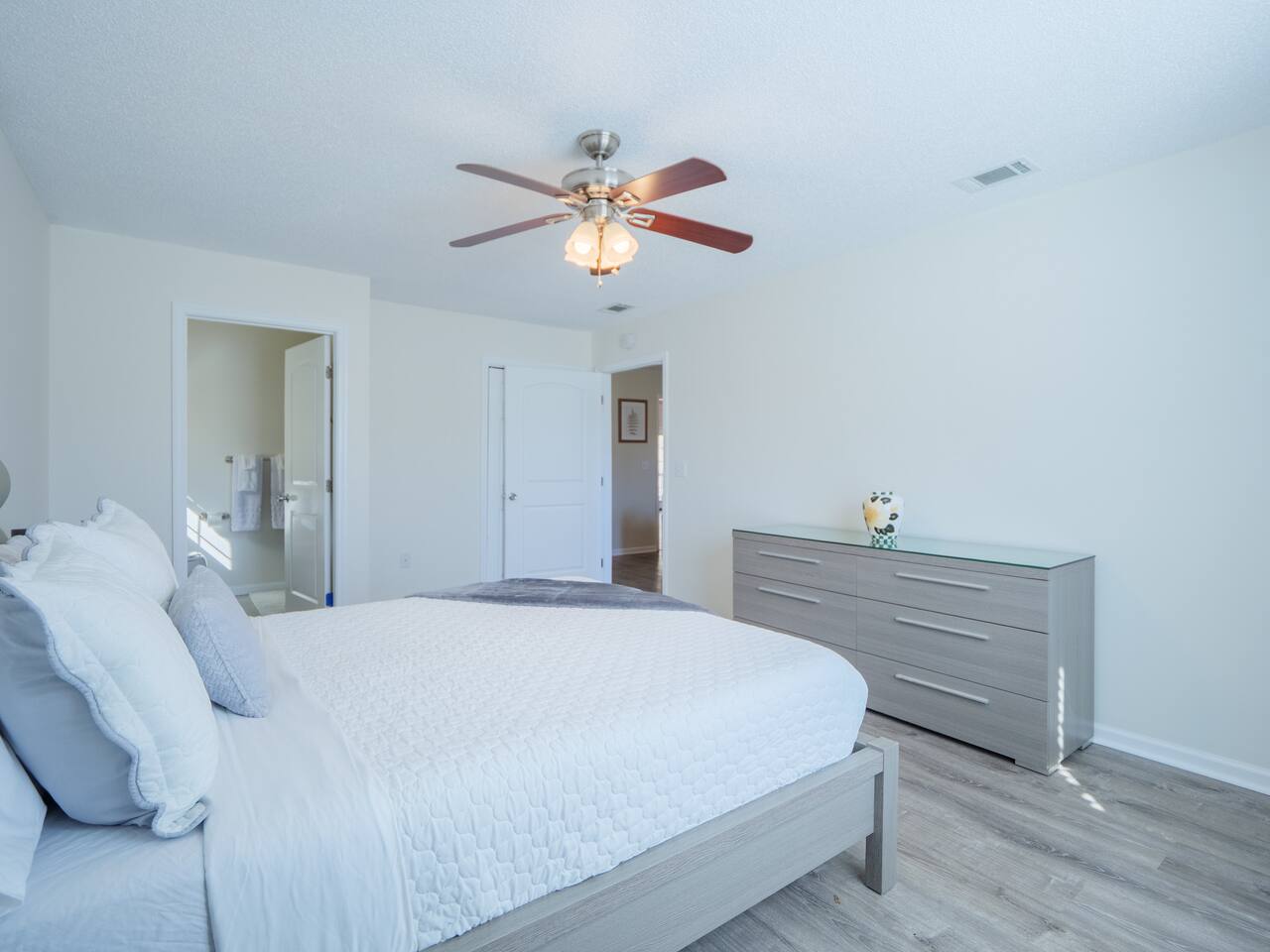 Primary bedroom with queen bed and dresser
