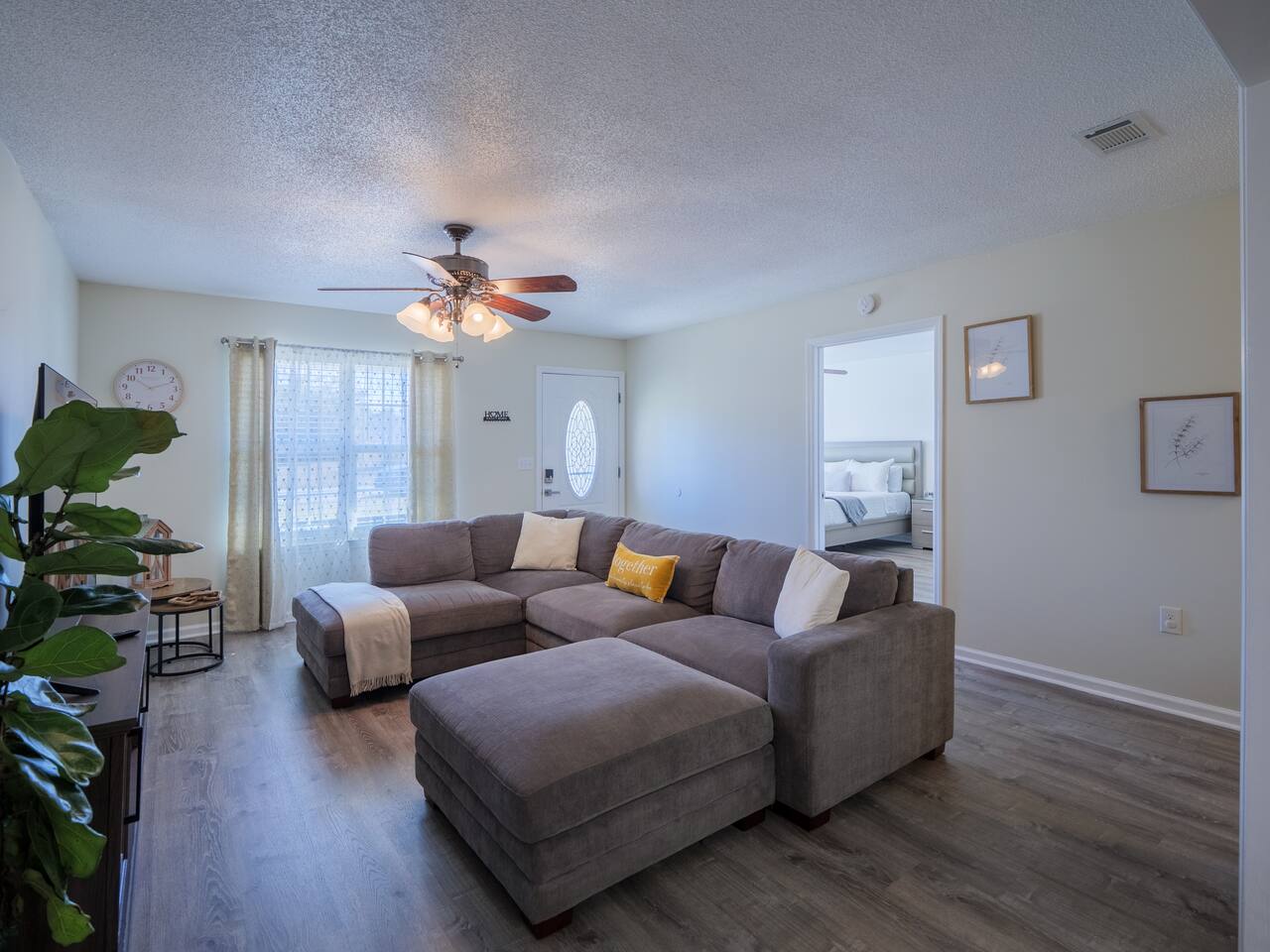 Living room sectional and ottoman by the windows