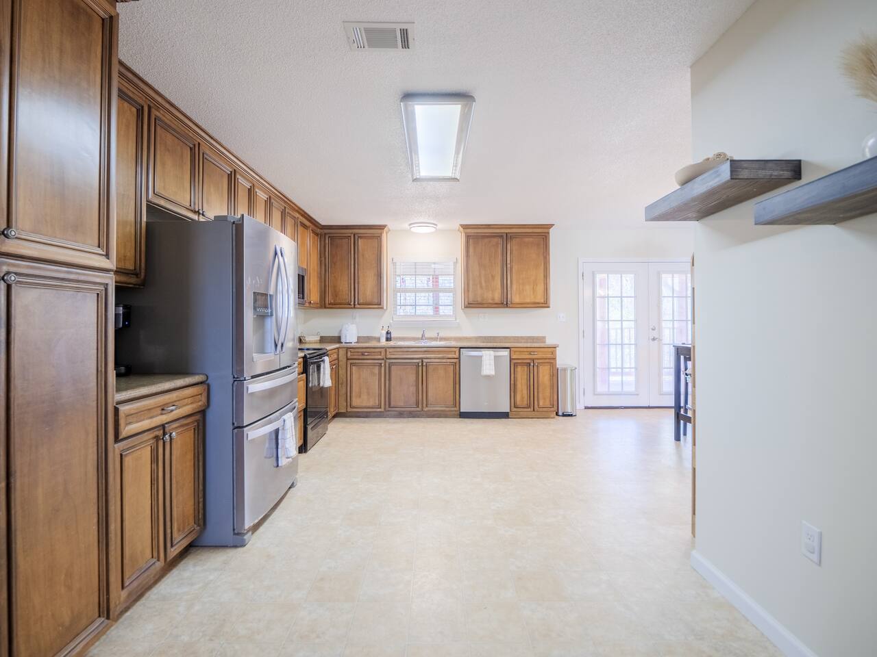 Kitchen with floor-to-ceiling wood cabinets and French-door refrigerator