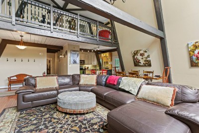 Spacious loft style living with plush sectional seating and an open balcony above. Perfect for movie nights, game days, or simply stretching out after a day of adventure.
