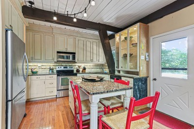 Cook like you are at home in this bright kitchen with granite counters, ample cabinetry, and charming red bar stools. Fully equipped for family meals or weekend feasts.