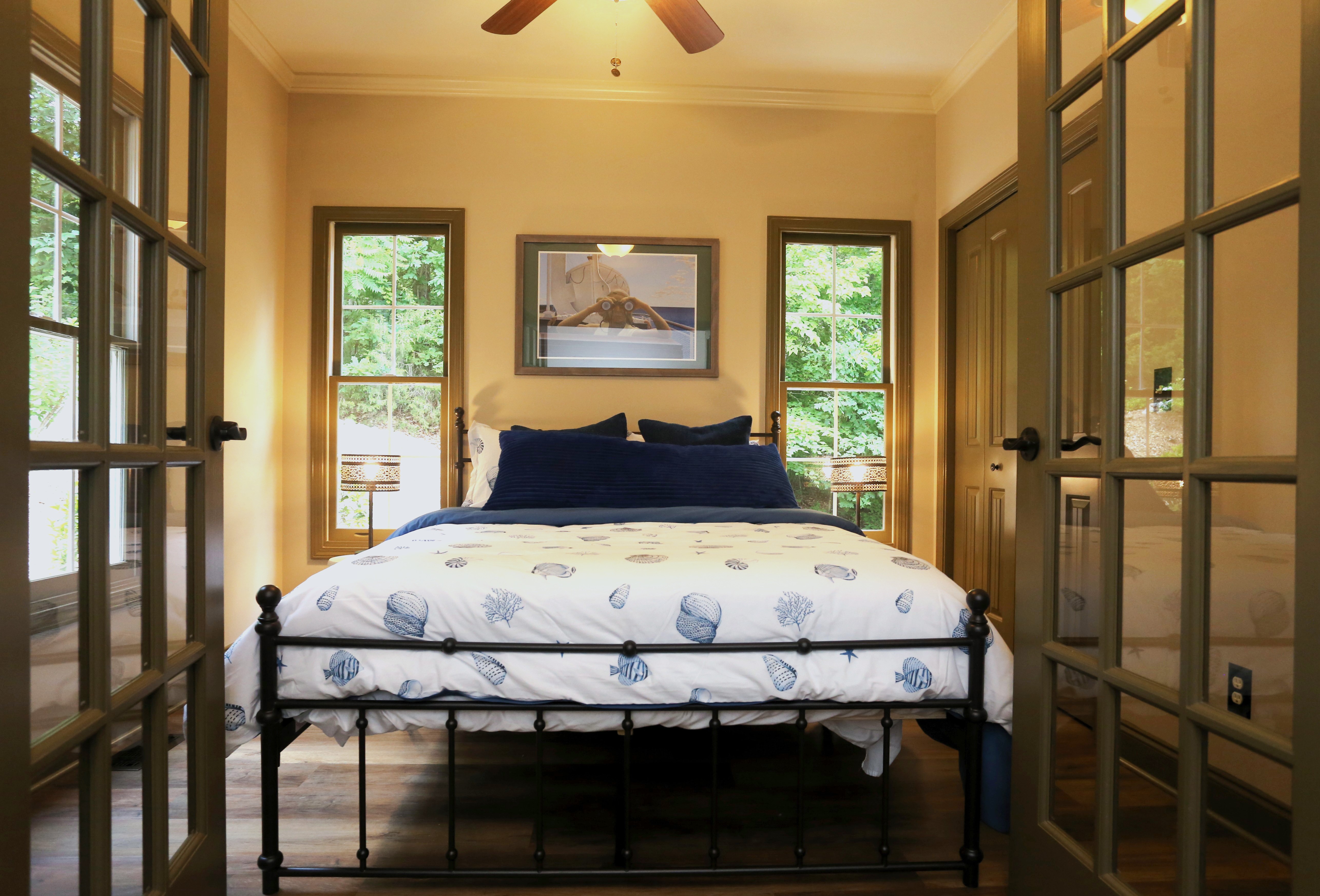 Charming sunlit bedroom with wooded views and cozy coastal touches
