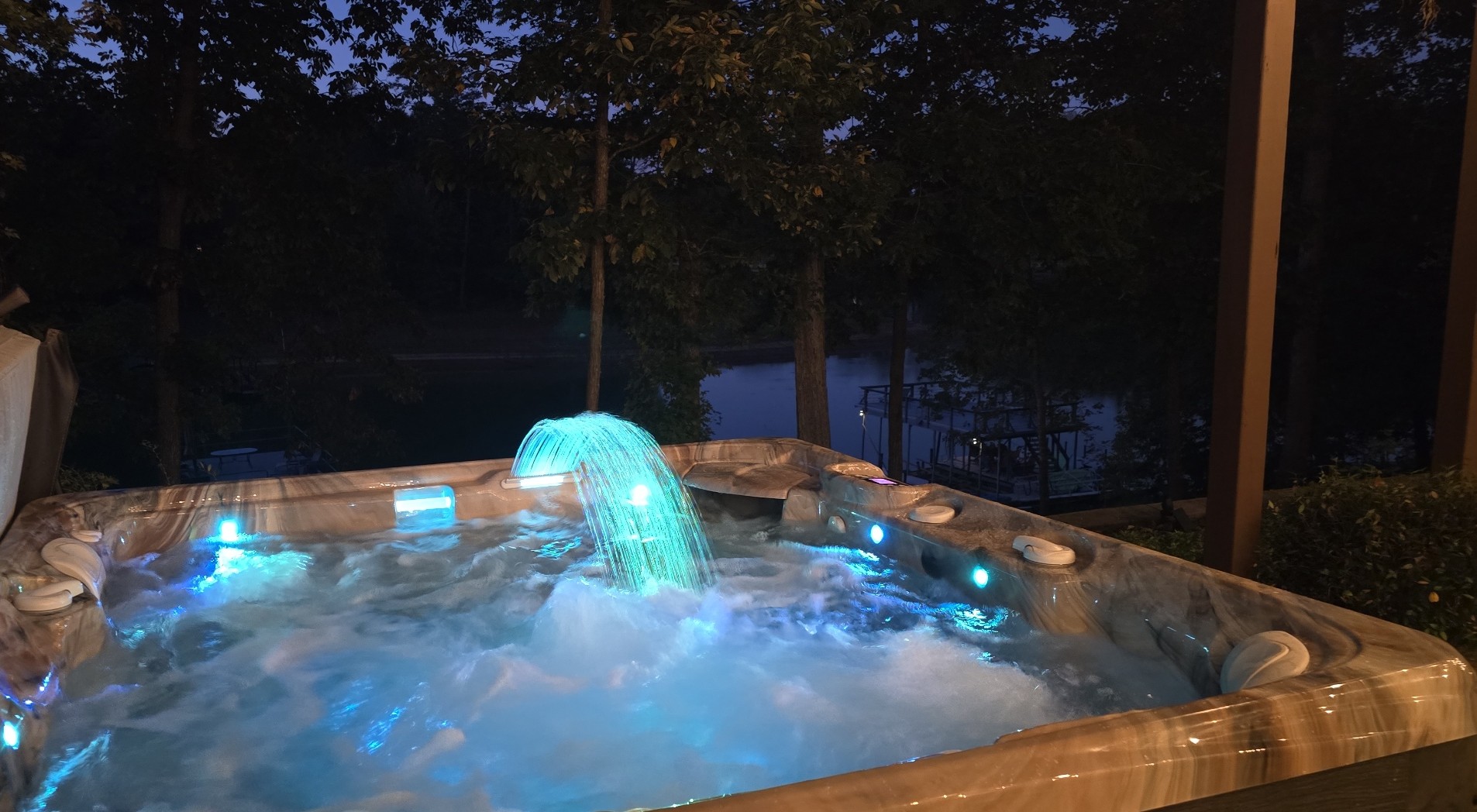 Relax in the glowing outdoor hot tub with serene nighttime views