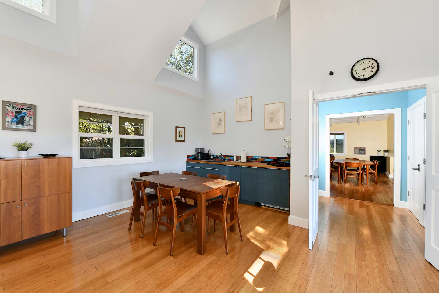 Sunlit dining with vaulted ceilings, mid‑century charm, hardwood floors.