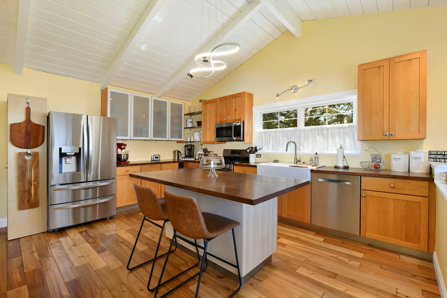 Bright chef’s kitchen with island, farmhouse sink & stainless appliances