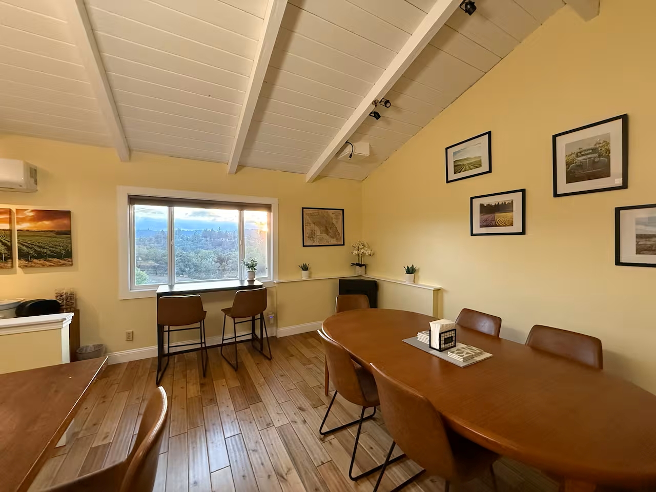 Sunny dining room with vaulted ceiling, seats six, valley‑view window bar.