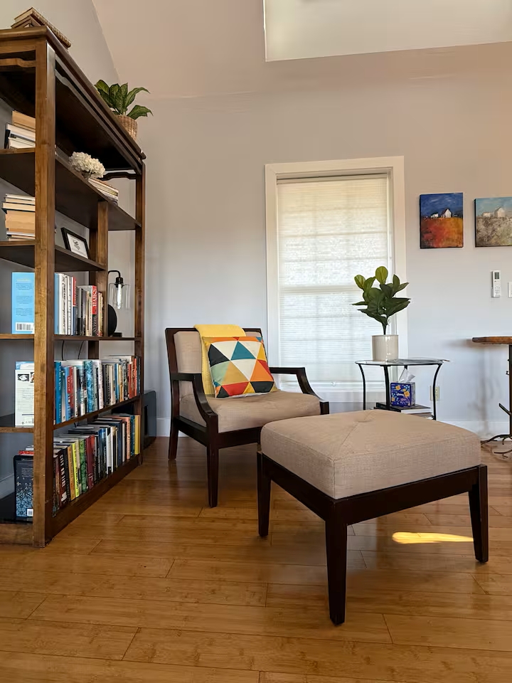 Sunny reading nook with library, comfy chair & ottoman, skylight.