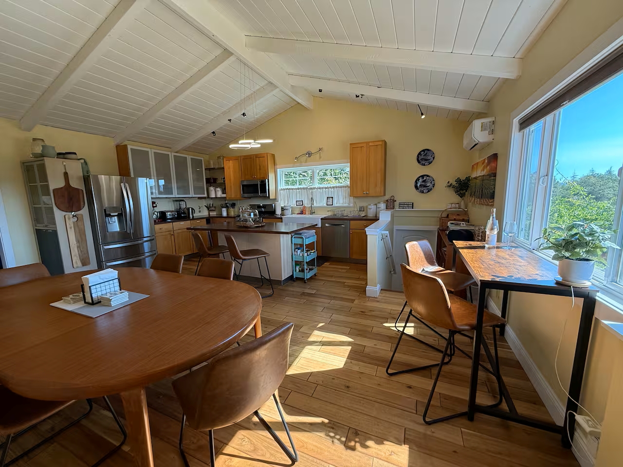 Sunny vaulted kitchen with stainless appliances, dining & leafy views
