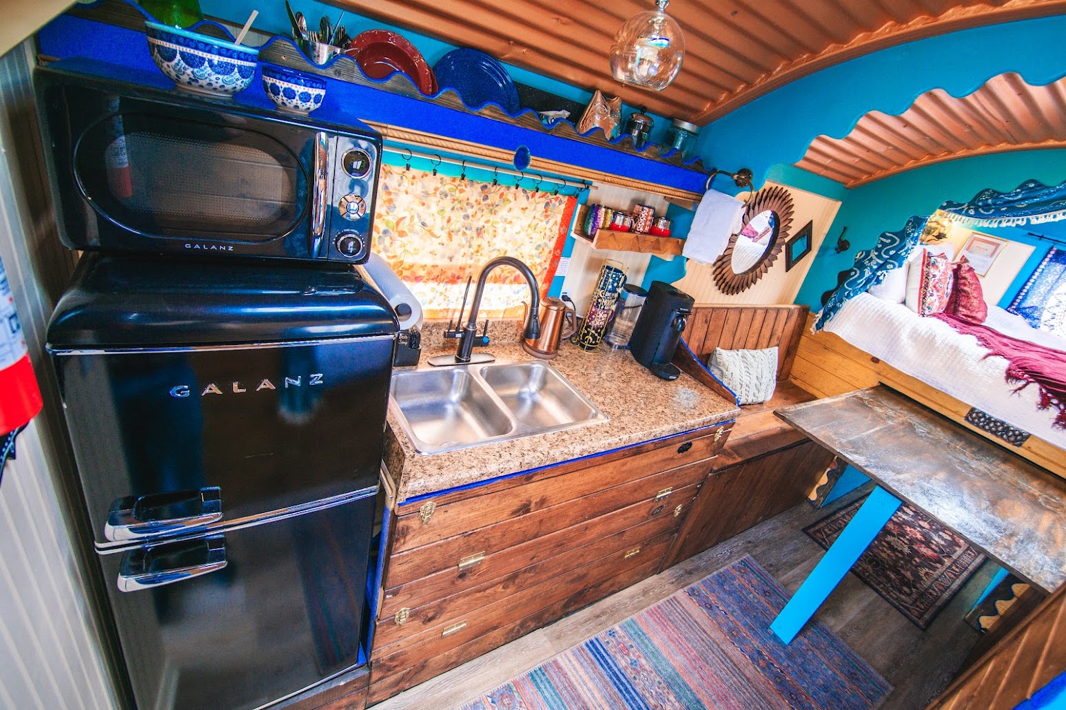 Kitchenette in the wagon with Fridge, Freezer, microwave, dishes, Nespresso and dishes.