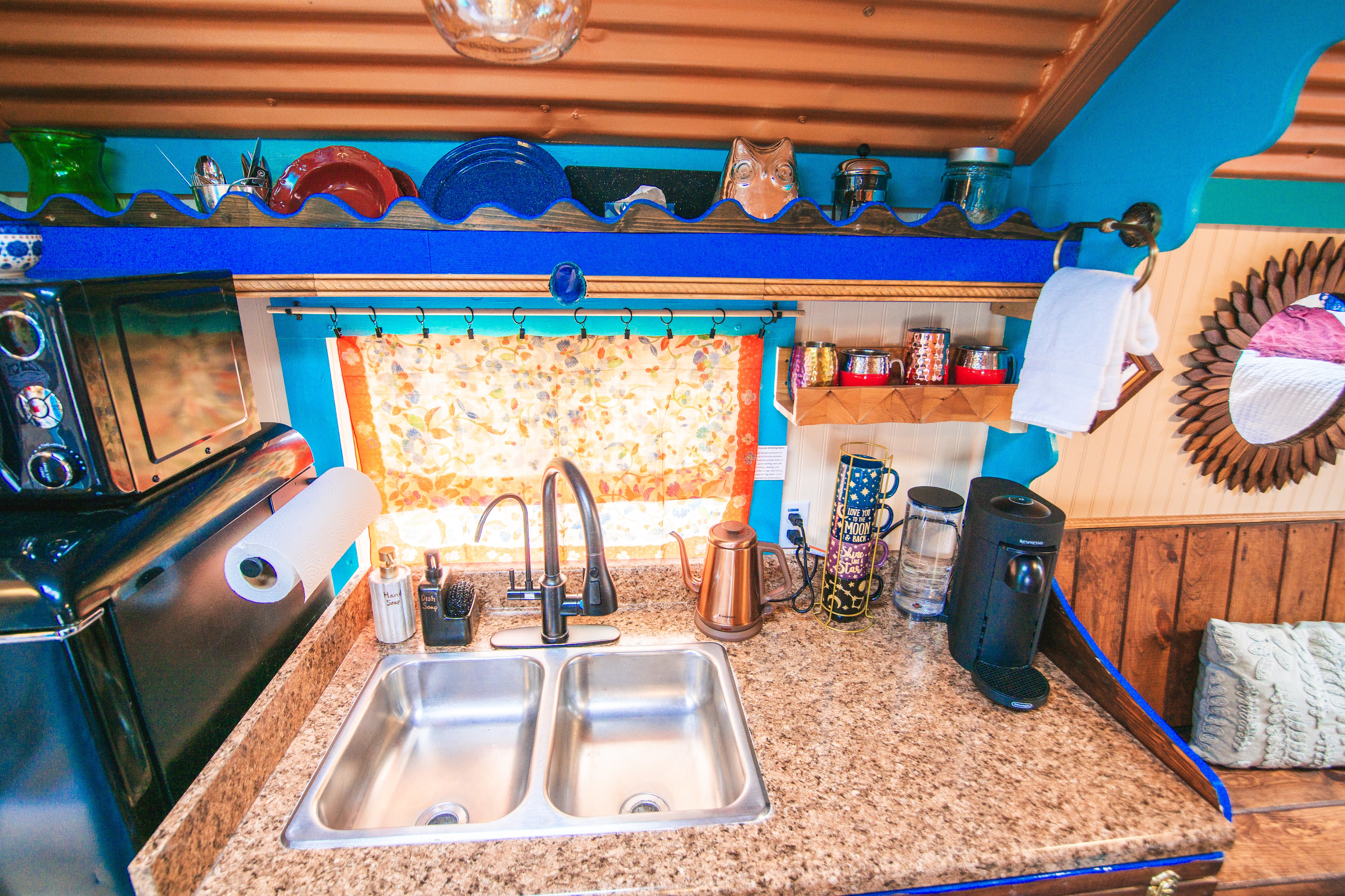 Bright, colorful kitchenette with double sink and cozy coffee station