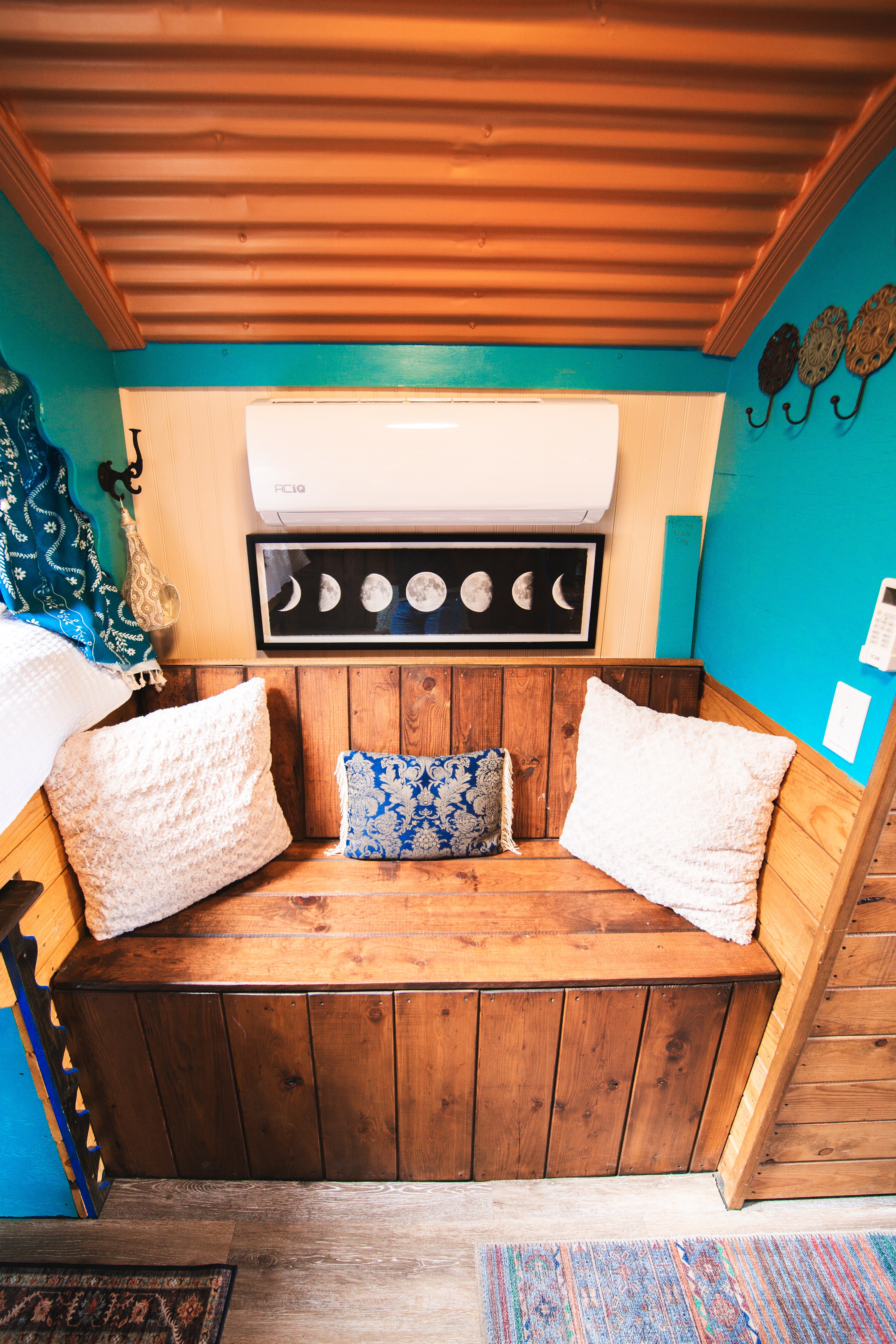 Cozy built-in seating nook with bold colors, wood accents, and eclectic charm