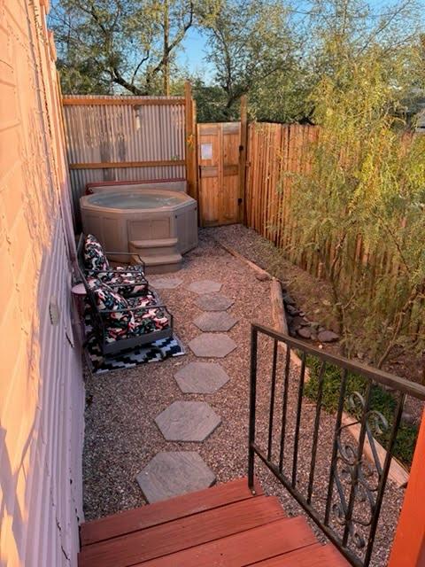 Private fenced patio with hot tub and cozy lounge seating