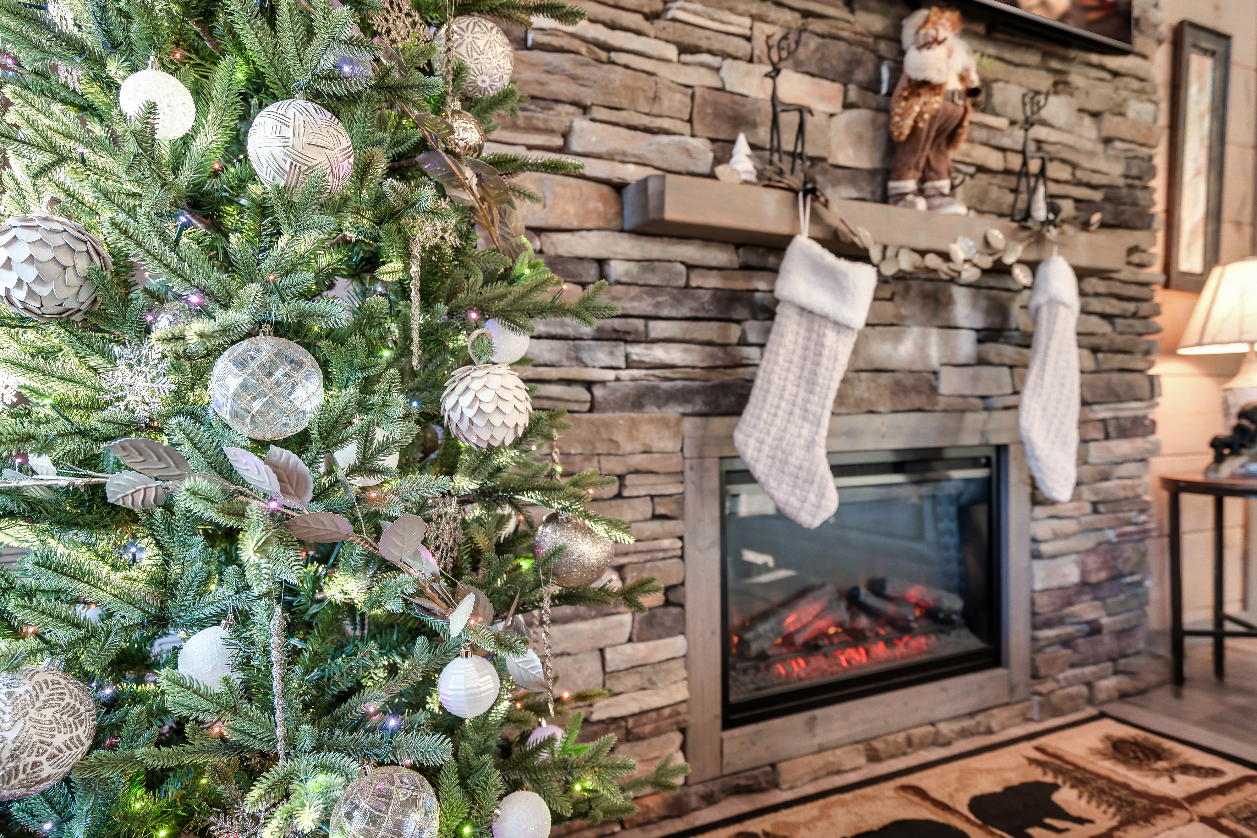 Cozy stone fireplace and elegant holiday tree for a festive mountain stay