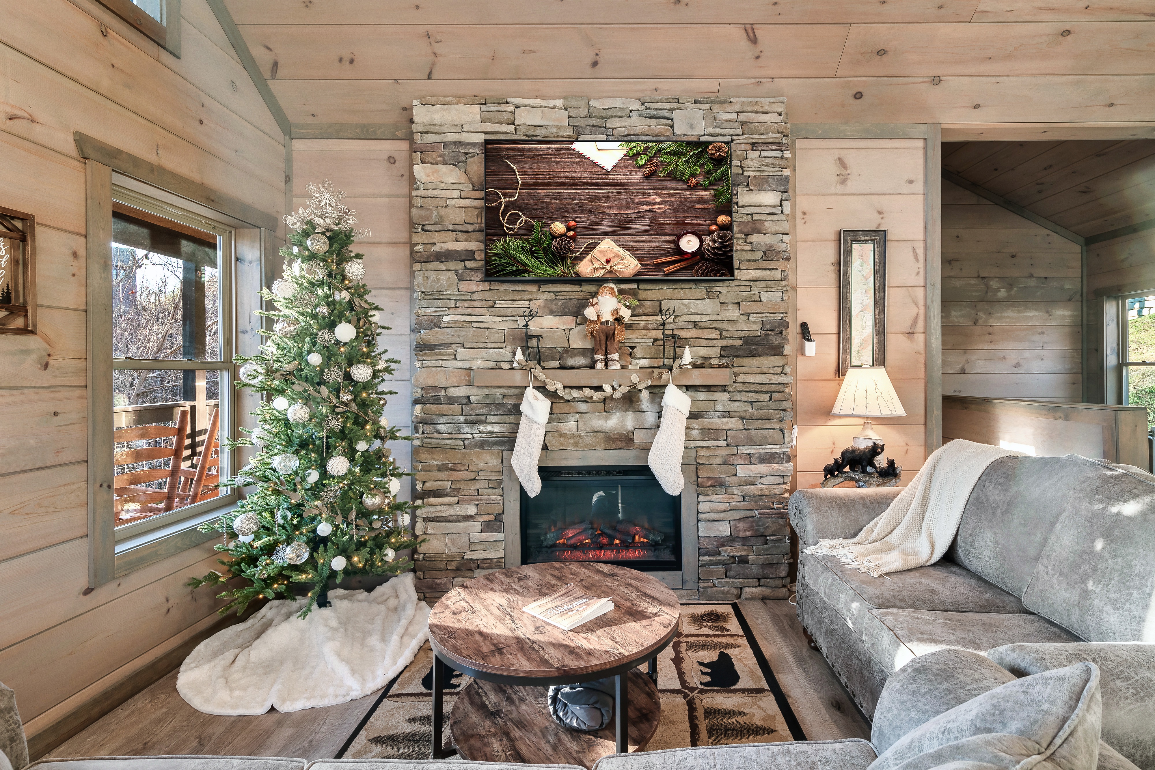 Cozy cabin living room with stone fireplace and festive holiday charm