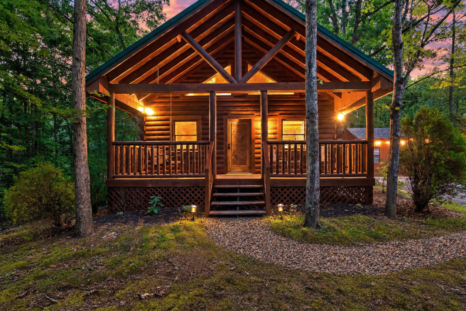 Cabin all lit up at dusk, string lights glowing and the covered porch ready for a quiet evening